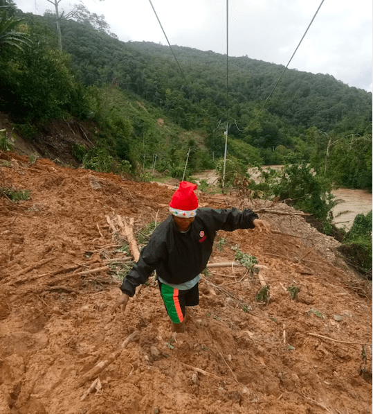 Warga di Lore Barat berusaha melalui jalan yang longsor saat banjir untuk bisa ke kebun . Foto : Mosintuwu/Raru