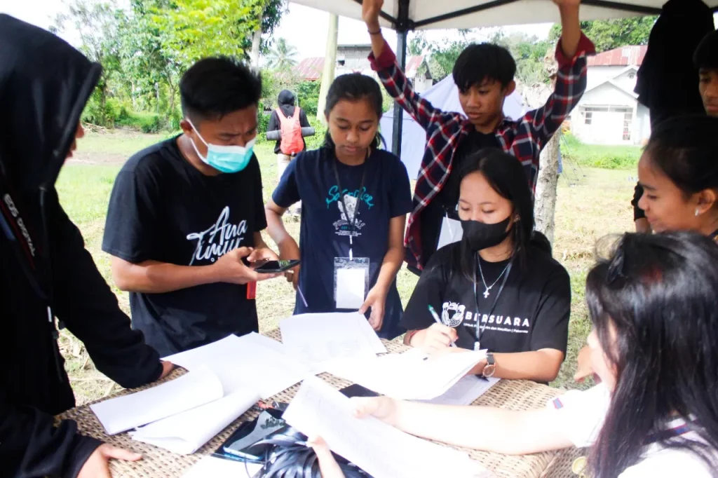 Relawan Mosintuwu sedang membantu peserta melakukan registrasi . Foto : Yardin